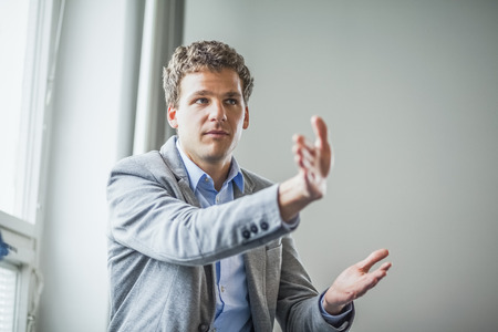 Young businessman looking away while giving presentation in office