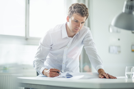 Young businessman working at desk in officeの写真素材