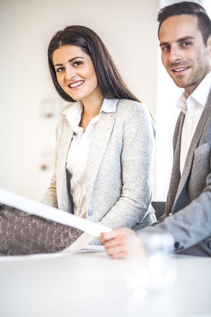 Portrait of business people working at desk in officeの写真素材