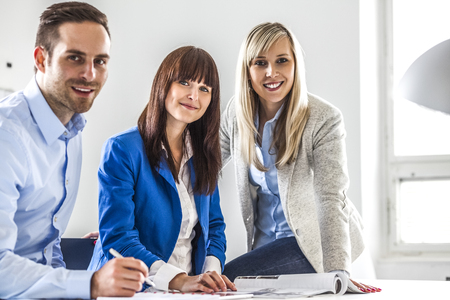 Portrait of young businessman and businesswomen working together in officeの写真素材