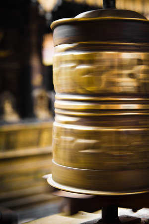 A long exposure shot of a spinning golden prayer wheel in the Golden temple, Patan, Nepal.の写真素材
