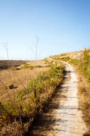 Dirt path winding through fields in the countryside around Wied il-Mielah. Gozo, Malta, Zebbug.の写真素材