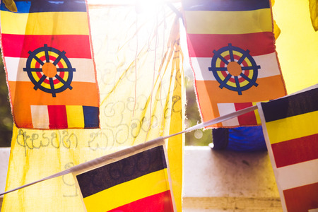 Colourful buddhist prayer flags with sunlight shining through them at a temple in Anuradhapura, Sri Lanka.の写真素材