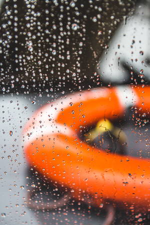 Orange life preserver on a boat during a rain storm, shallow depth of fieldの写真素材