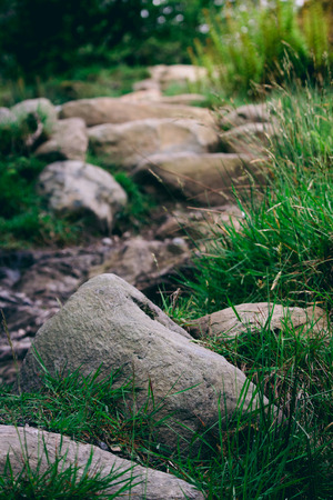 Closeup abstract of rocks on a walking hiking trekking path up into the scottish hills. portrait orientationの写真素材