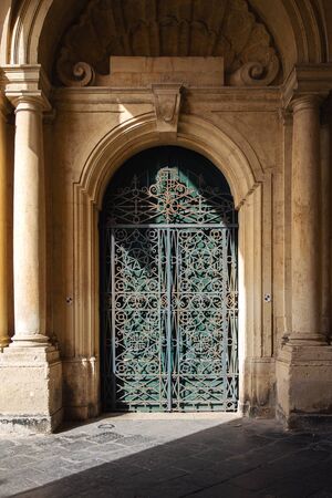 Ornate metal and wood door to the grandmaster's palace courtyard in Valletta, Malta