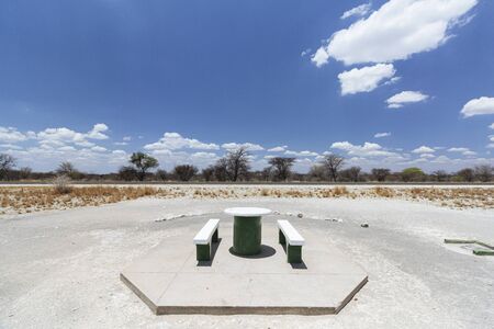 Concrete picnic table and benches placed beside a tree for shade, typically placed every 10-20kms along roads in Namibia. C38 road to Etosha.の写真素材