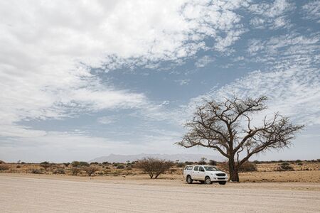 Large offroad vehicle stopped on the side of the road  for a picture while driving north on the C35 route to Twyfelfontein, Namibia, Africaの写真素材
