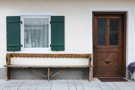 Brown door and green shuttered window of a traditional mountain hut in the Bavarian alps.の写真素材