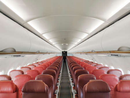 Empty interior cabin of an Airbus A320 Neo with red seats and trim. Many airlines face dire straits as they face a worldwide shutdown of travel due to Covid-19のeditorial素材