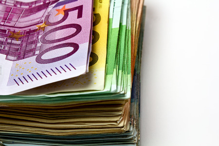 Different euro bills are spread out on a table in the form of a stack of money. の写真素材