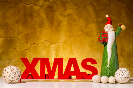 Red XMAS character on a brown background. Santa Claus is ringing  with a golden bell.の写真素材