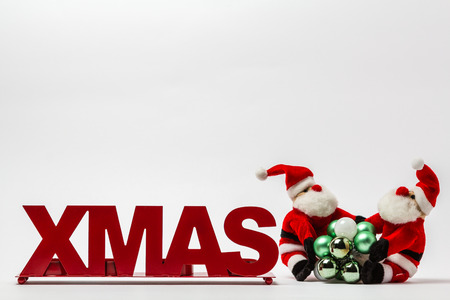 XMAS red lettering on a white background with Christmas balls and a Santa Claus.の写真素材