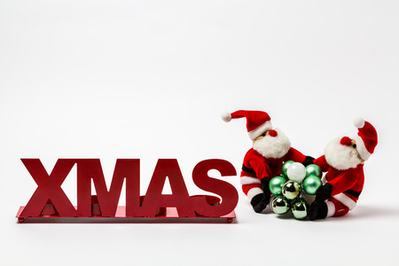XMAS red lettering on a white background with Christmas balls and a Santa Claus.の写真素材