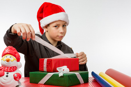 Boy binds a loop around colored Christmas presents, Closeupの写真素材