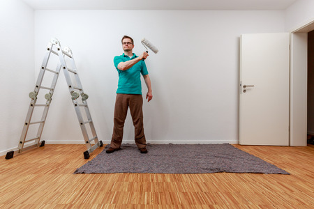 Man paints on imaginary concept panel in an empty roomの写真素材