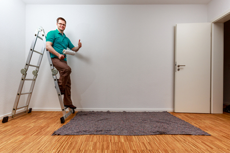 Man on a ladder showing thumbs Upの写真素材