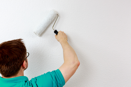 Man paints wall in white, close upの写真素材