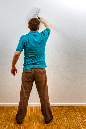 Man paints wall in white, vertical formatの写真素材