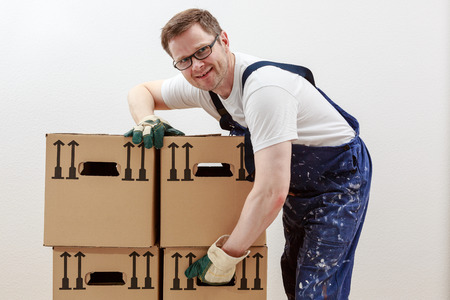 Man lifts heavy boxesの写真素材
