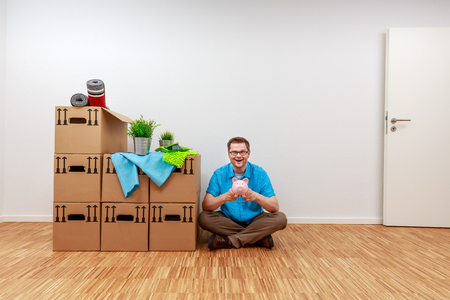 Man is pleased with his arrival, with his piggy bank in his handの写真素材