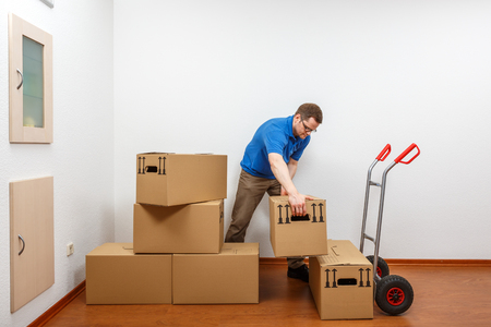Man is packing cartons on a sack barrowの写真素材