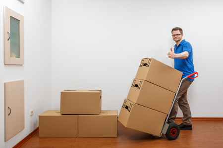 Man is packing cartons on a sack barrowの写真素材