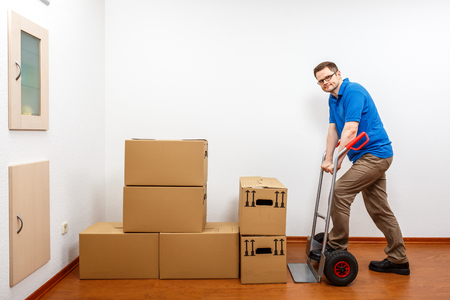 Man is packing cartons on a sack barrowの写真素材
