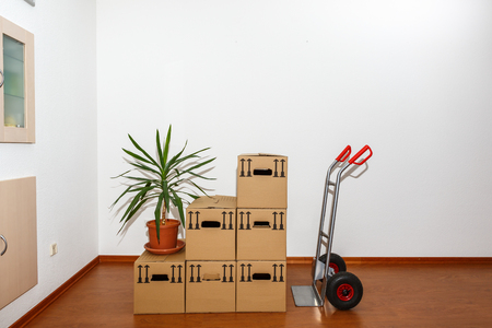 Stacked cardboard boxes in front of a sack barrowの写真素材