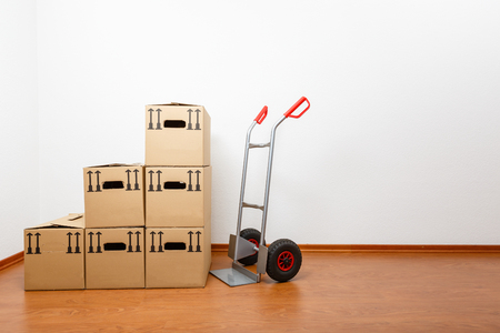 Stacked cardboard boxes in front of a sack barrowの写真素材