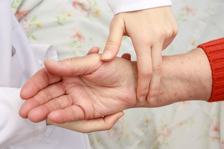 Nuirse taking patient's pulse
