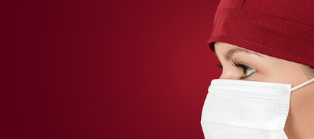 Surgeon doctor in mask with red backgroundの写真素材