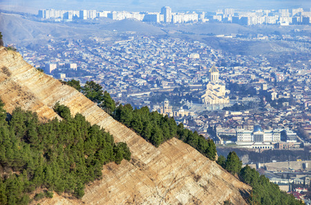 The view of Tbilisi from the mountains. In the frame diagonally visible mountain with pine trees on...