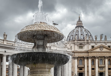 Fountain in Piazza San Pietro in Vatican against The Papal Basilica of Saint Peter on a cloudy day. Rome, Italy.のeditorial素材