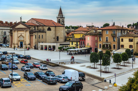 PESCHIERA DEL GARDA, ITALY - OCTOBER 1, 2018: View on Church of St. Martino Vescovo and Piazza Ferdinando di Savoia with cars and people.のeditorial素材