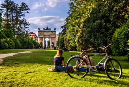 Milan, Italy - May 7, 2017: People rest and walk in the Sempione Park near Arco della Pace known as Arch of Peace, one of the most famous landmarks, in the historic center of the city.のeditorial素材