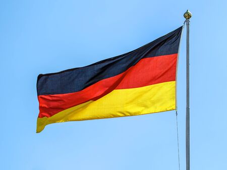 The national flags of Germany on the background of clear blue sky.