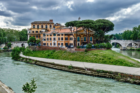 Rome, Italy - May 5, 2018: View on Isola Tiberina or the Tiber river Island with Fatebenefratelli Hospital and the part of Ponte Garibaldi bridge on a cloudy day.のeditorial素材