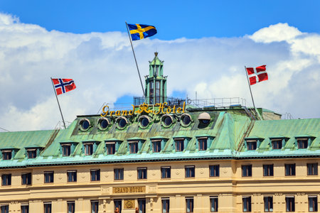 Stockholm, Sweden - July 1, 2019: The top of the facade of Grand Hotel building with cloudy sky in background.のeditorial素材