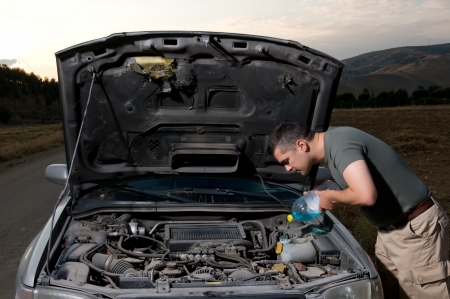 Adult man filling windshield washer fluid on his carの写真素材