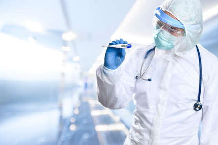 Medical doctor wearing protective workwear holds digital thermometer showing high fewer