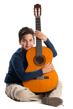Child guitarist looking at the camera isolated on white background.の写真素材