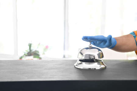 Coronavirus free tourism concept; customers ring hotel bell using gloves at new normalの写真素材