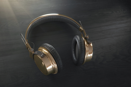 Realistic Gold Headphones (earphone) on wooden background. Closeup  with blurred background and area for a text. Audio technology, gadgets and music concept. 3d renderingの写真素材