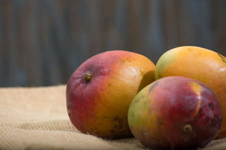 table with mango fruits. dark background with space for text.の写真素材