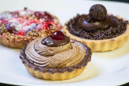 chocolate, strawberry and cream pies. space for text.の写真素材