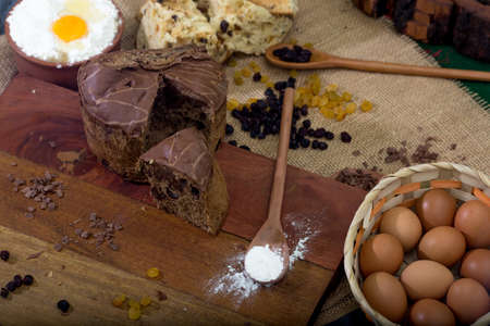 rustic table with panettone and ingredients. eggs and flour.の写真素材