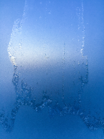 Background of frosty pattern on glass in winterの写真素材
