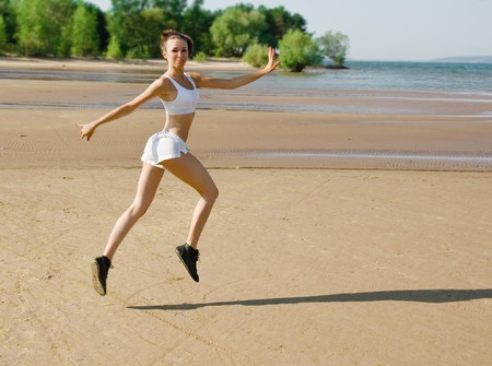 Young woman running alone on the beachの写真素材