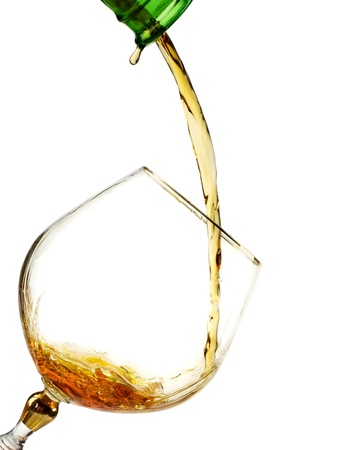 Brandy being poured from  bottle to the glass isolated on white の写真素材